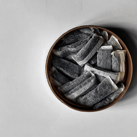 A collection of snus pouches arranged in a round container